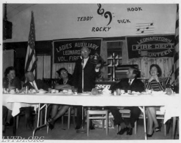 1970: Annual installation banquet at Leonardtown Wharf.  Charles Fenwick presents department with one of the original helmets from 1928. Looking on is Mary Jane and Johnny Scully, Mrs. Fenwick and Ann and Kennedy Abell.